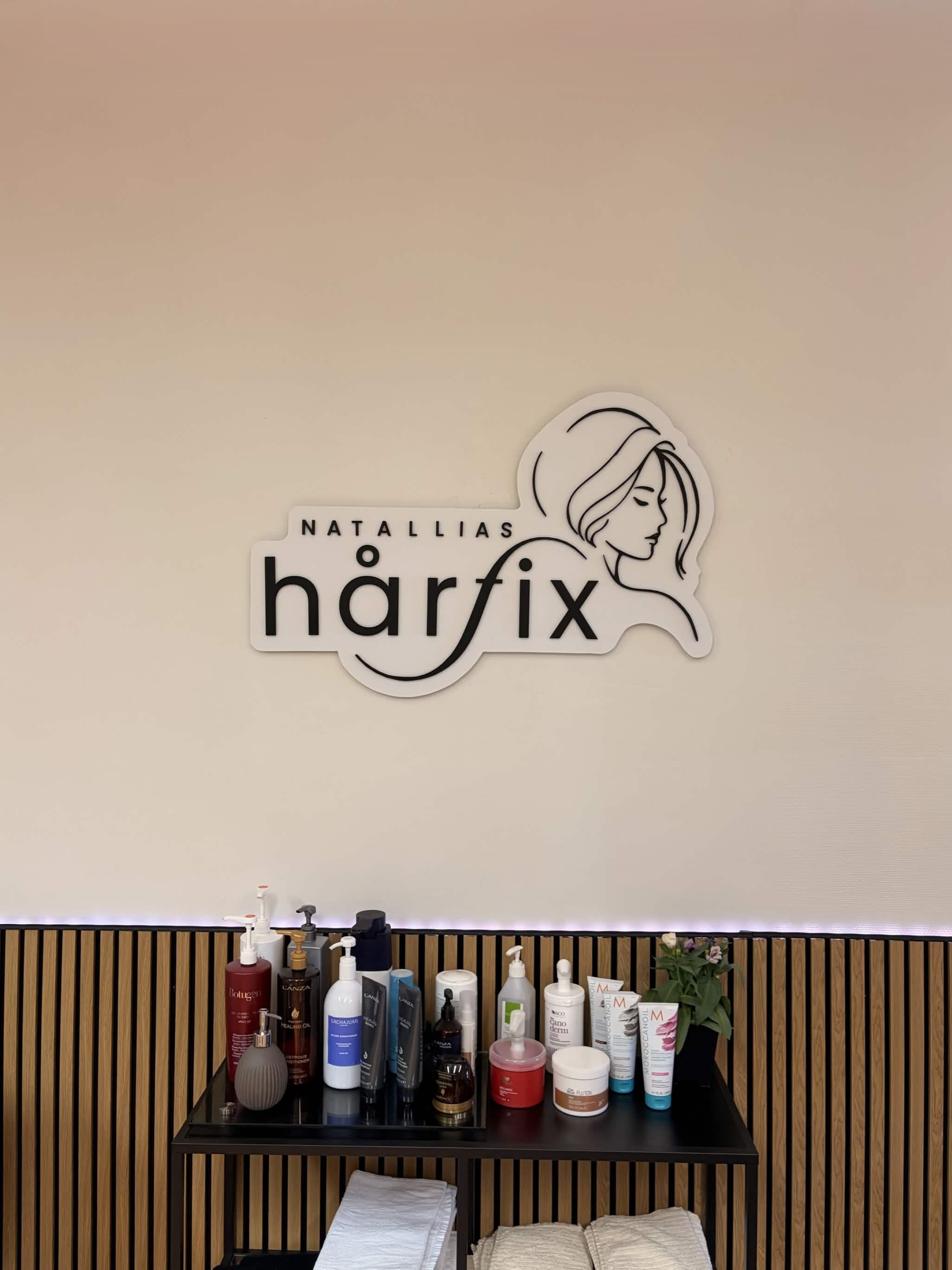Väggdetalj med produkthylla i salongen